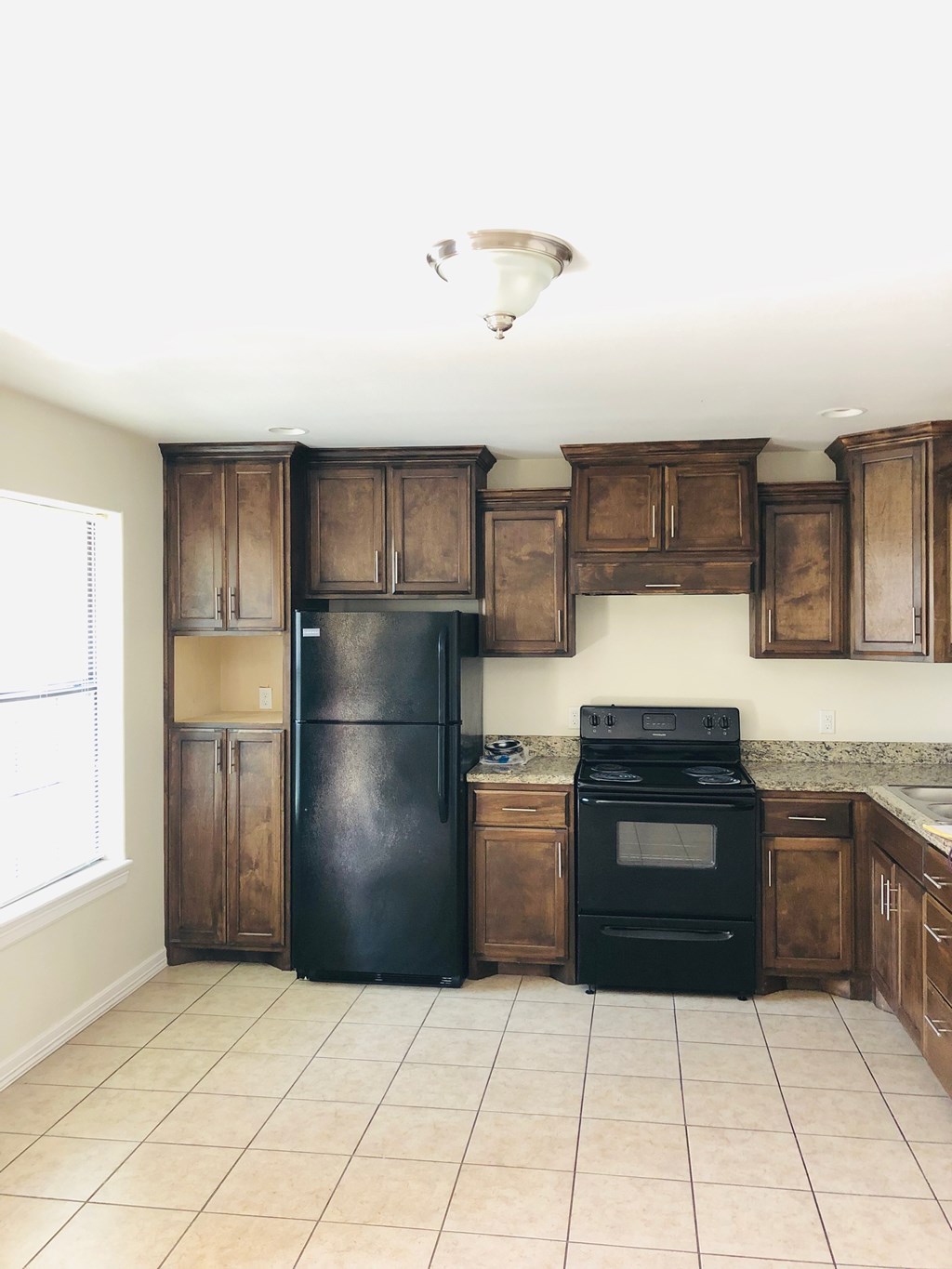 a kitchen with wooden cabinets and a black refrigerator