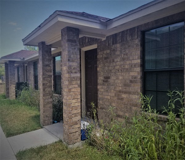 the front of a brick house with a sidewalk