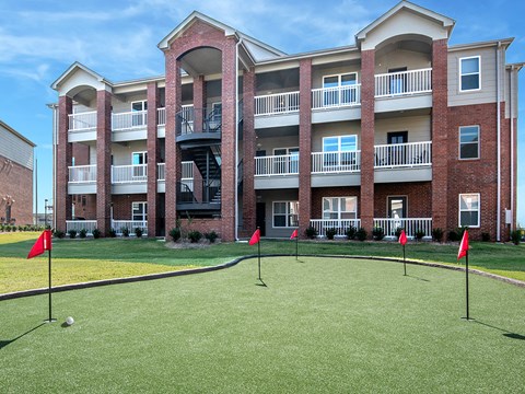 an exterior view of an apartment building with a golf course