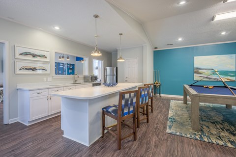 a large kitchen with a pool table and a dining table