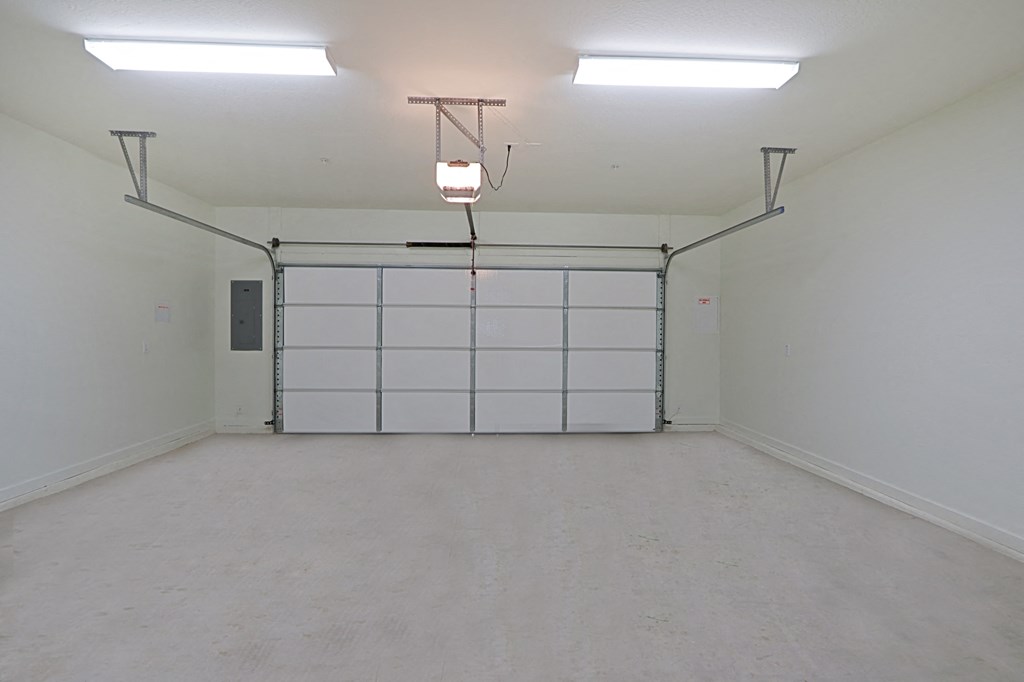 an empty room with a white wall and a garage door