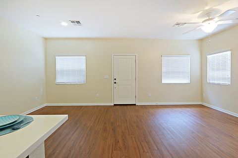 an empty living room with wood floors and a white door