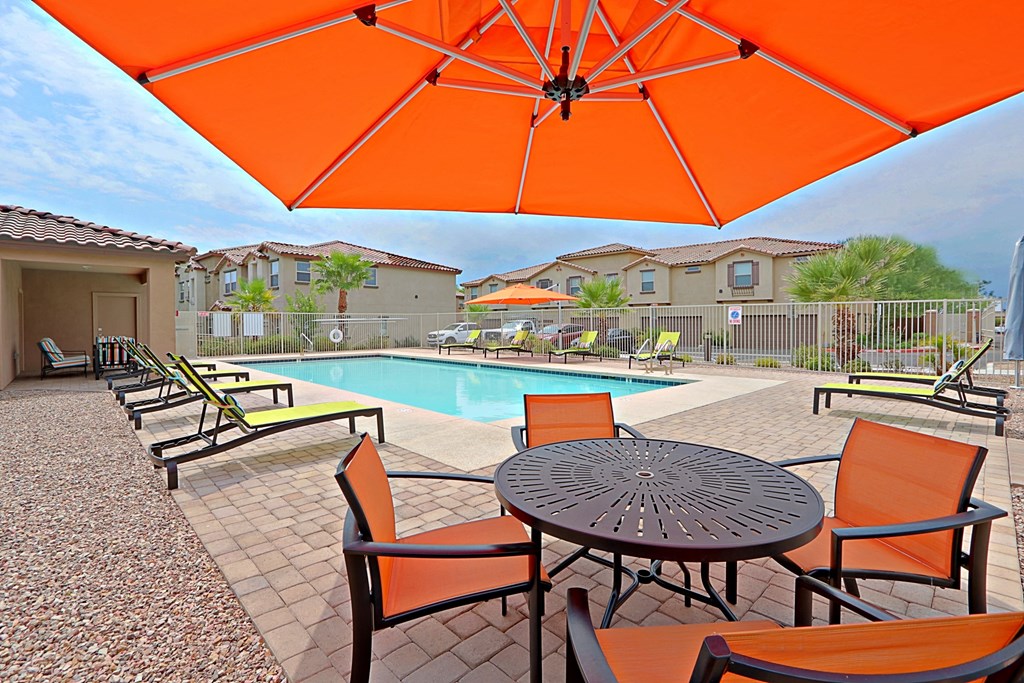 our apartments have a pool and a patio with chairs and tables