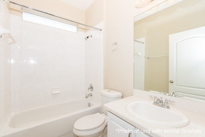a white bathroom with a sink toilet and tub