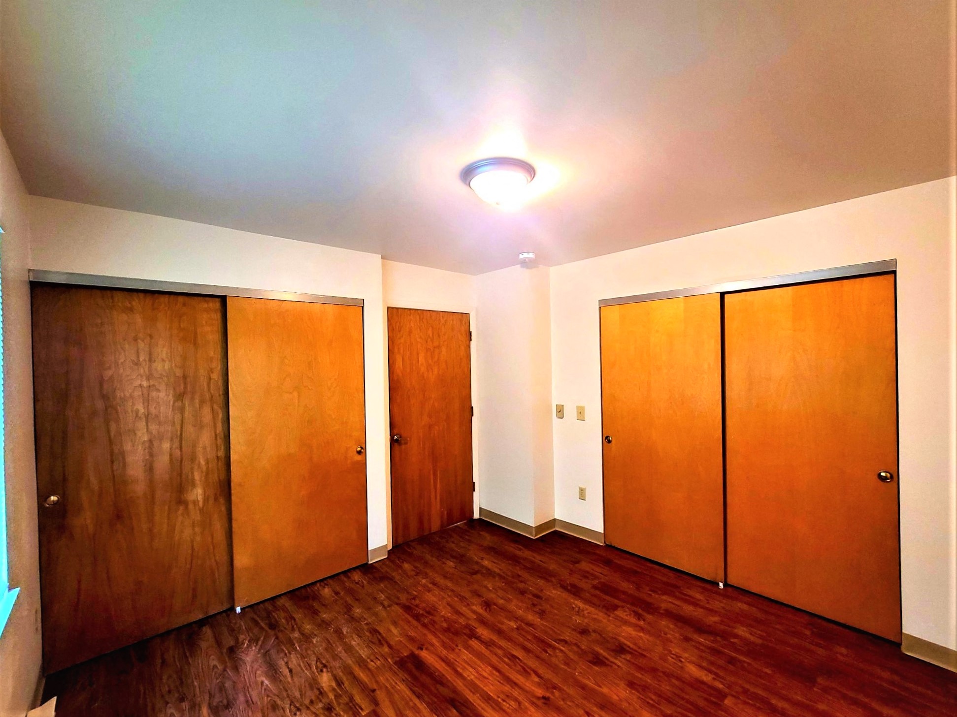 a empty room with wooden floors and closets
