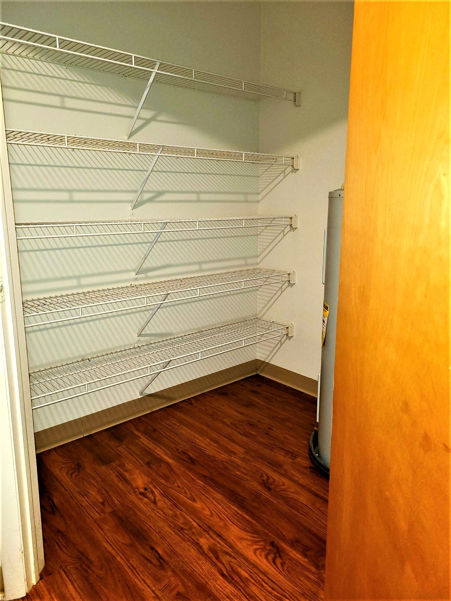 a closet with empty shelves and a wood floor