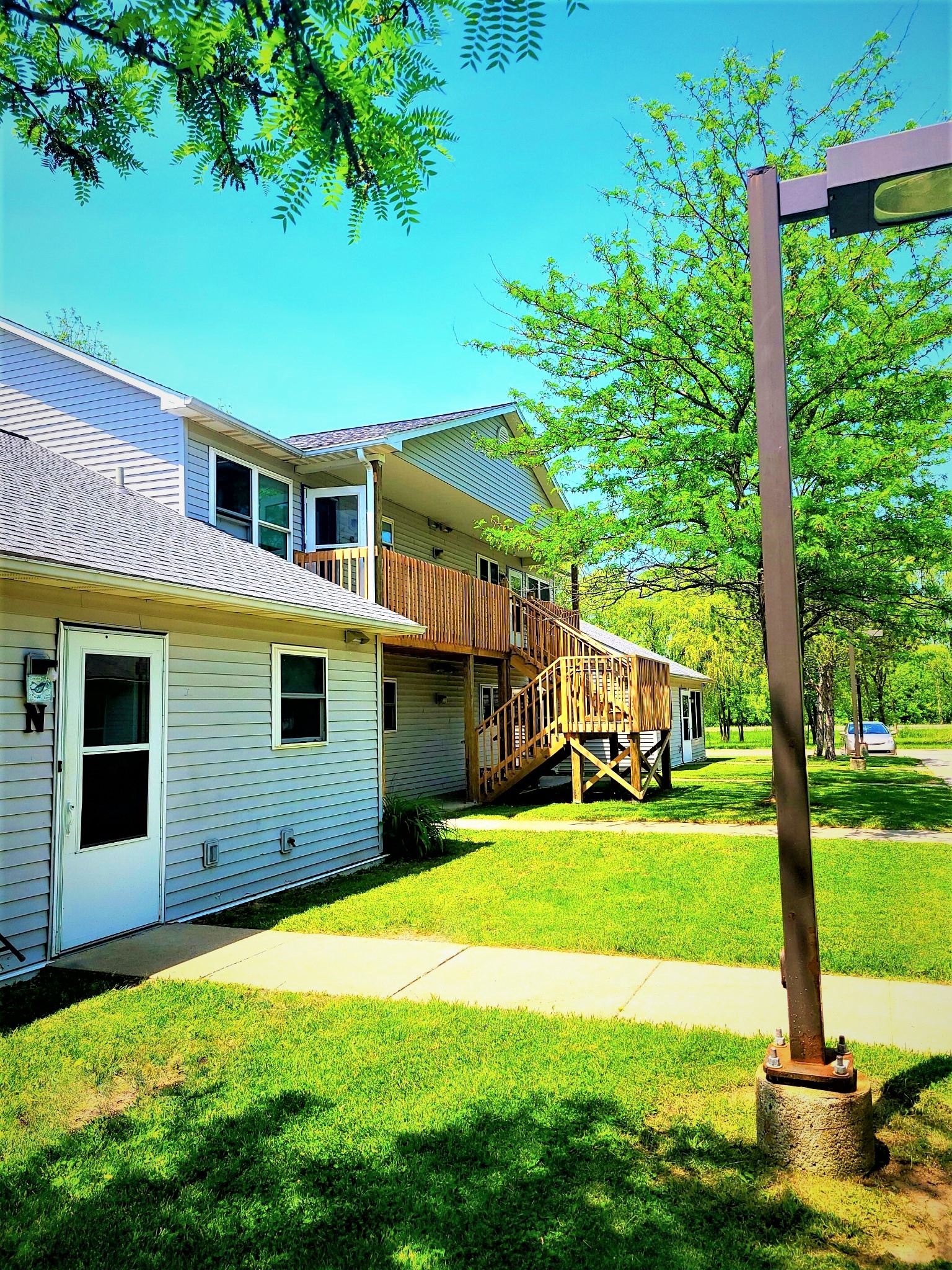 the side of a house with a porch and a street light