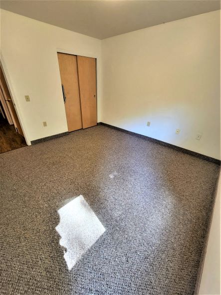 an empty living room with a piece of carpet on the floor