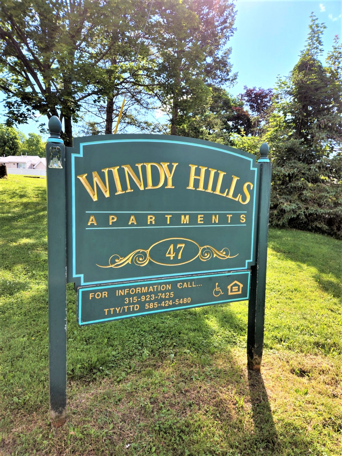 a sign for windy hills apartments in a park