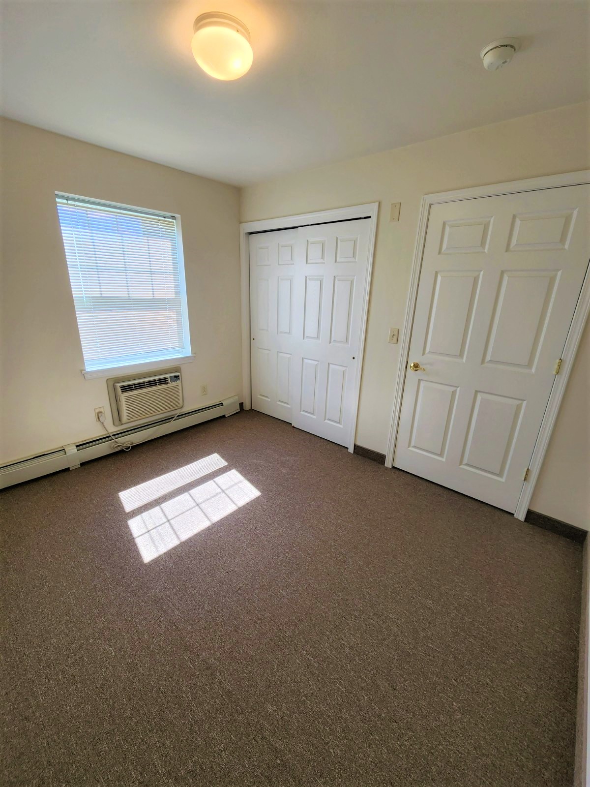 an empty room with two doors and a window
