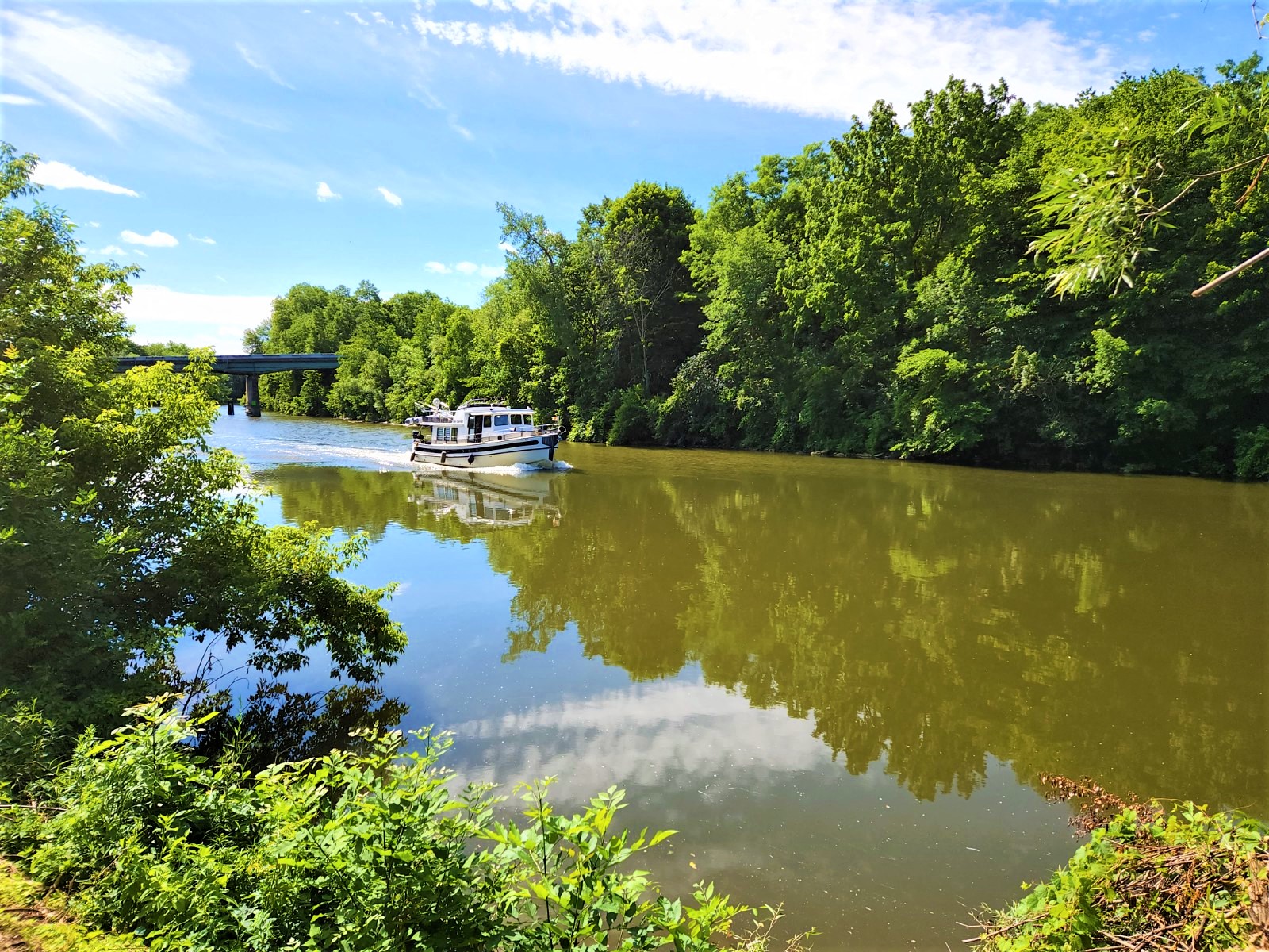 a boat on a river with a bridge in the background