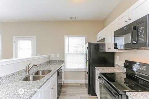 a kitchen with black appliances and granite counter tops