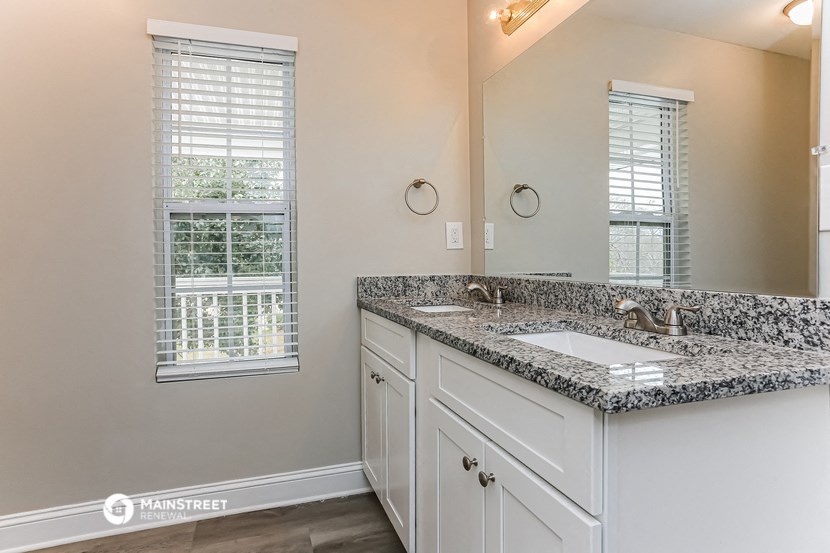 a bathroom with a sink and a mirror and a window