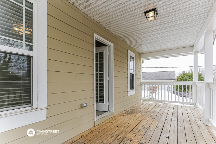 two windows and a door on a porch with a wooden deck