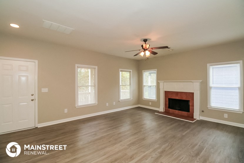 the living room with fireplace and ceiling fan