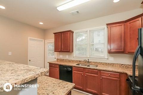 a kitchen with granite counter tops and wooden cabinets