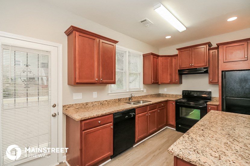 a kitchen with wood cabinets and granite counter tops and black appliances