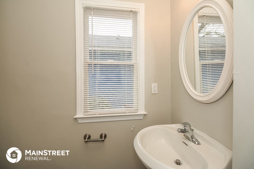 a bathroom with a sink and a mirror and a window
