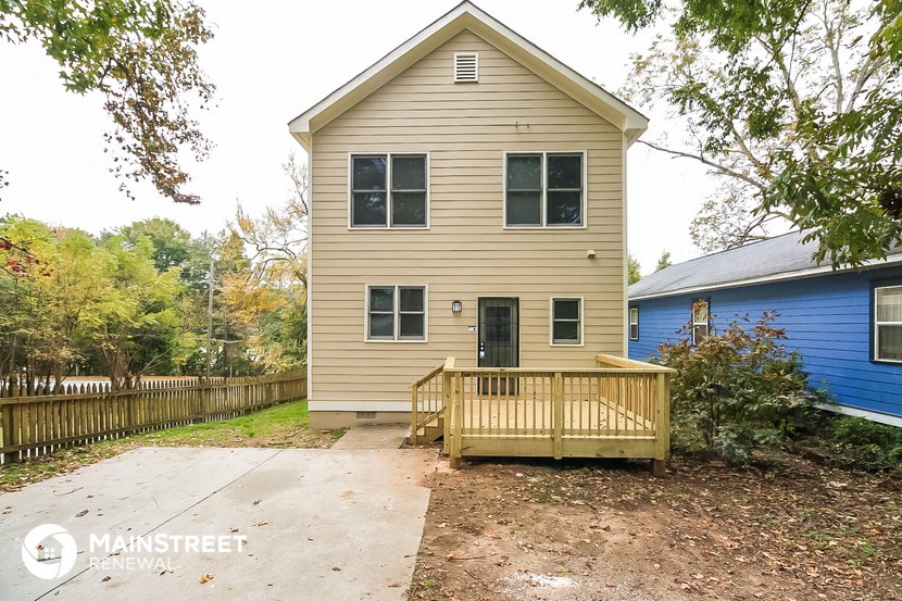 the front of a house with a porch and a wooden deck