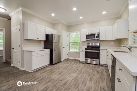 a kitchen with white cabinets and stainless steel appliances