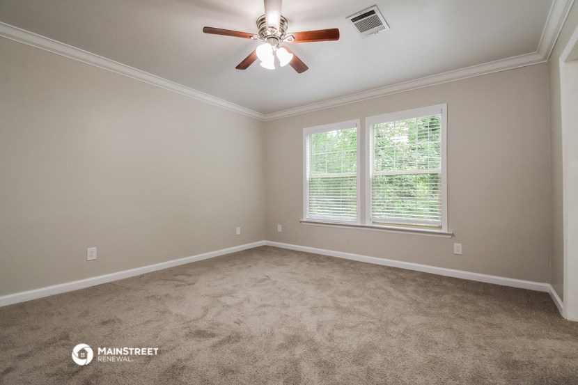 a bedroom with a ceiling fan and a window