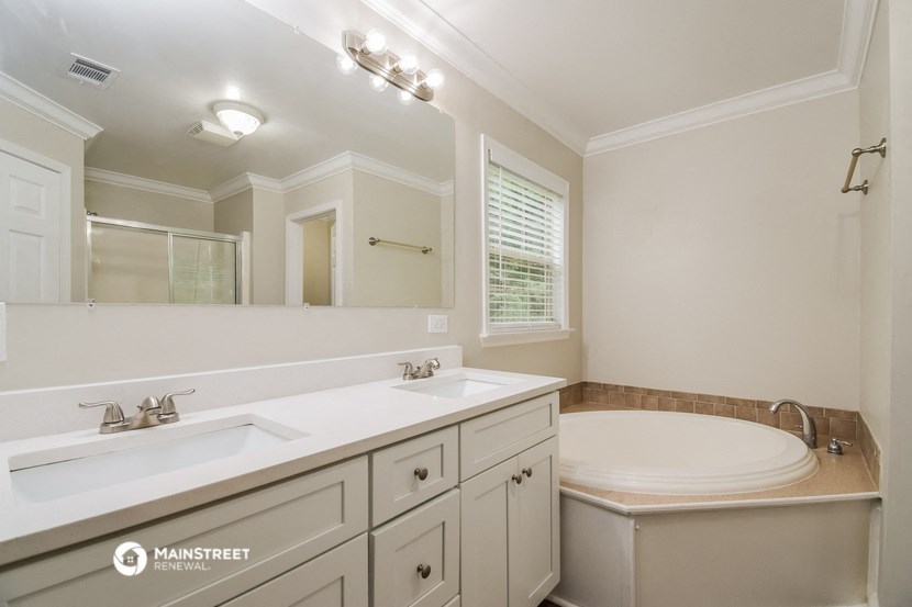 a bathroom with two sinks and a tub and a sink and a mirror