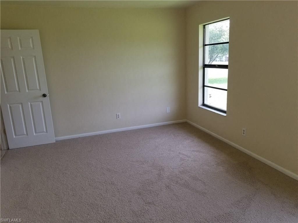 an empty room with a window and a door