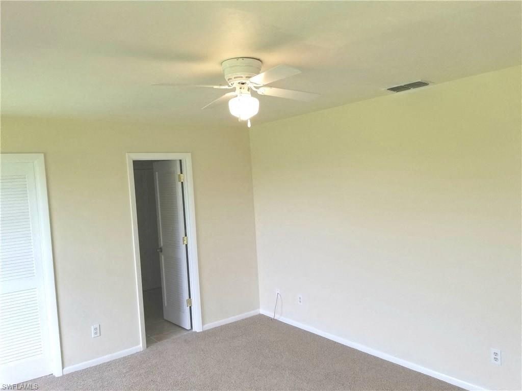 a bedroom with a ceiling fan and a door to a closet
