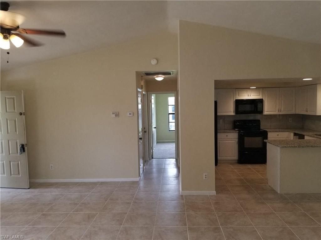 an empty kitchen and living room with a ceiling fan