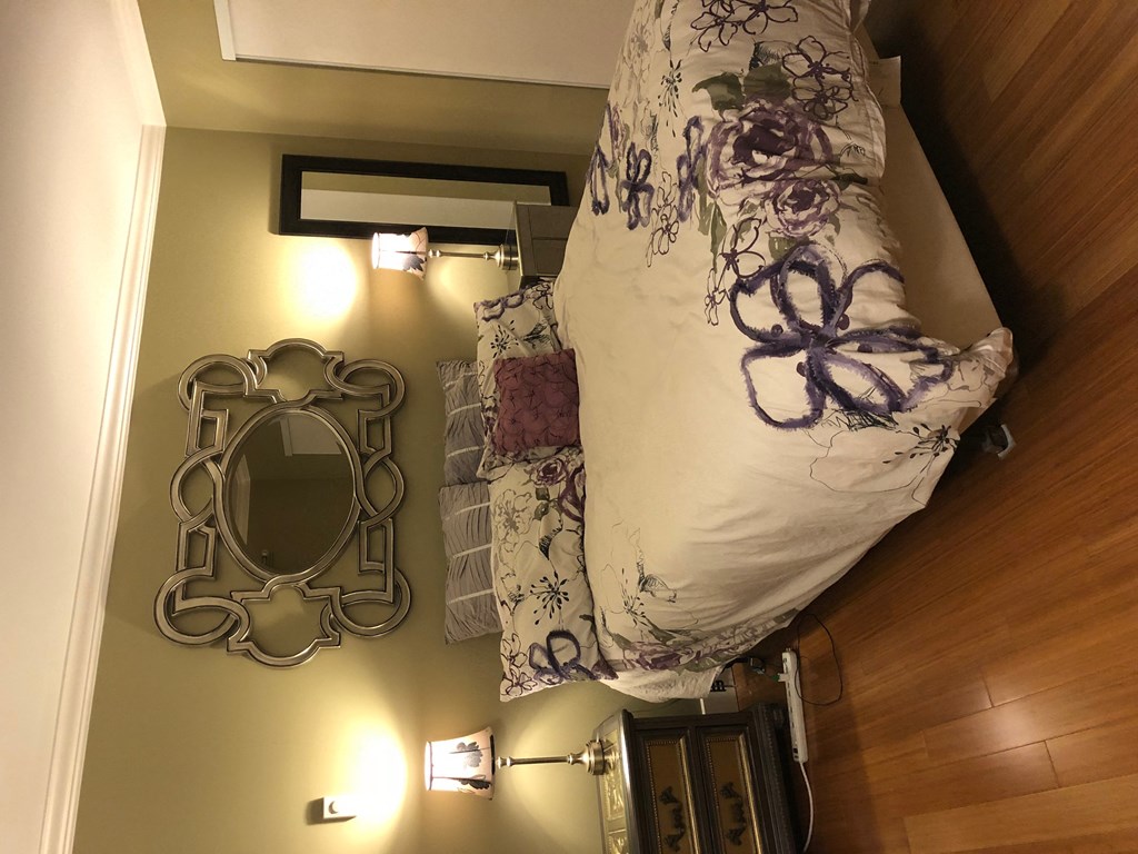 a small bedroom with a bed and a mirror