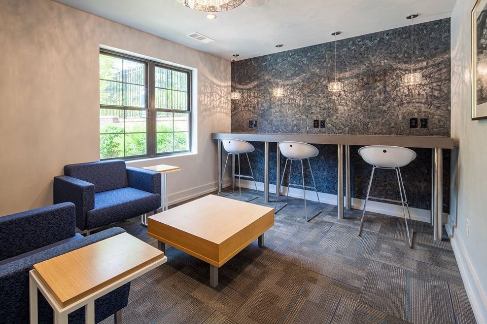 a common room with a bar and tables