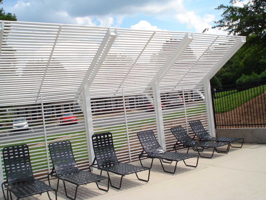 a group of chairs under a white metal canopy