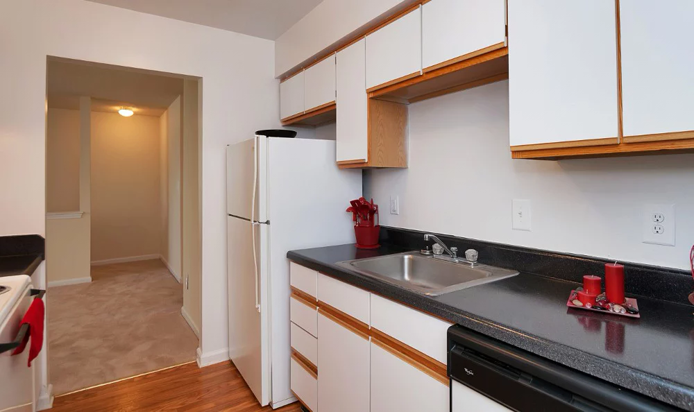 a kitchen with white cabinets and a sink and a refrigerator
