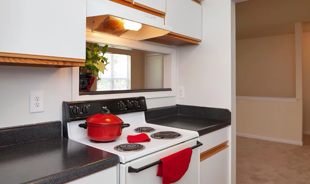 a kitchen with a red pot on the stove