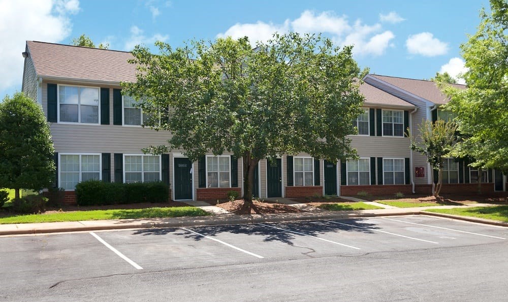 an empty parking lot in front of an apartment building
