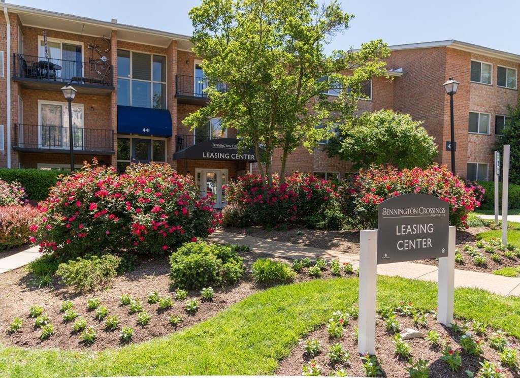 a leasing center sign in front of an apartment building