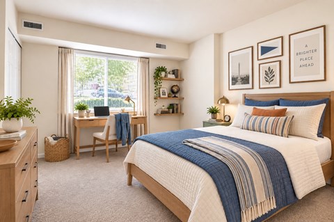 A bedroom with a bed, desk, chair, and window.