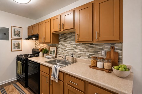 A kitchen with wooden cabinets and a black stove top oven.