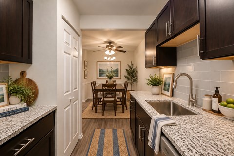 A kitchen with a dining table and chairs in the middle.