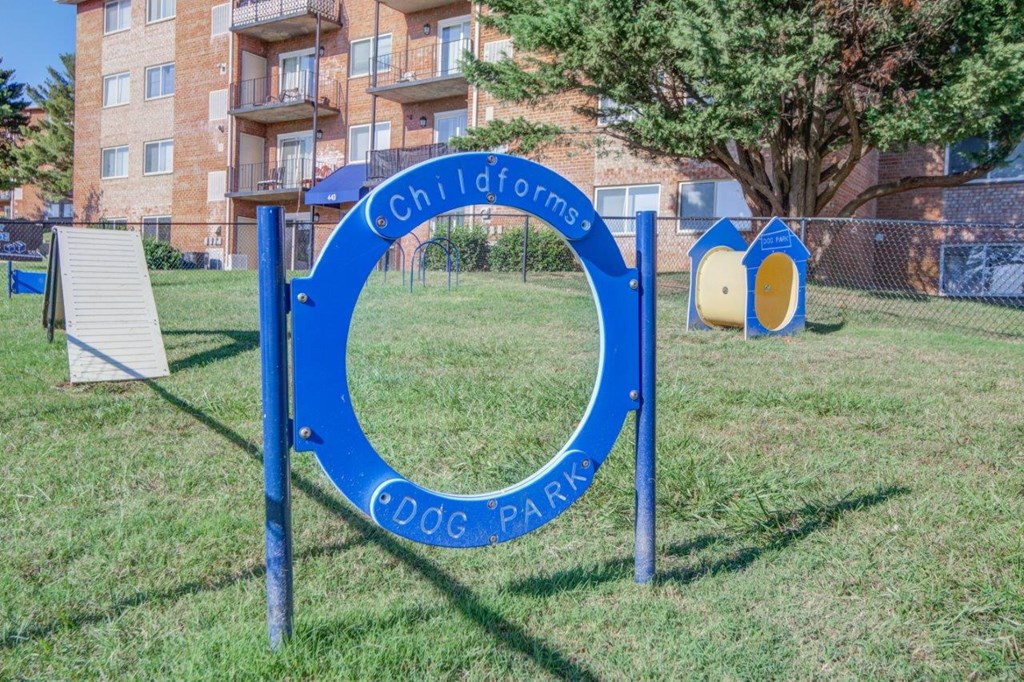 a blue sign in the grass in front of an apartment building
