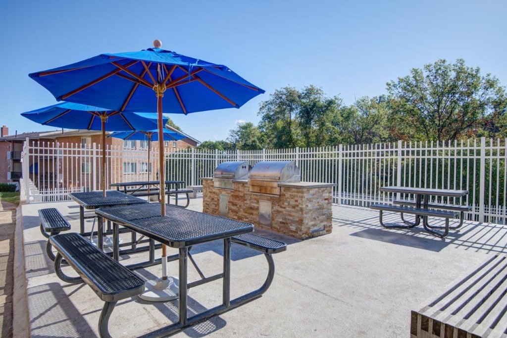 our patio has picnic tables with umbrellas and a grill