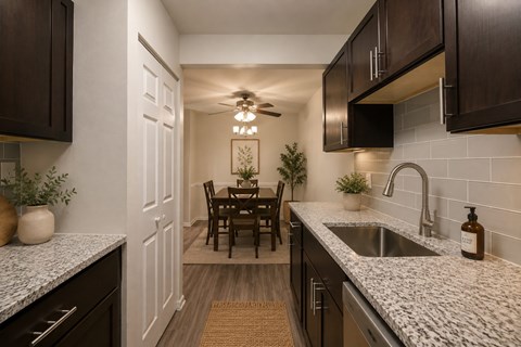 A kitchen with dark brown cabinets and a white door.