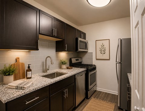 A kitchen with dark brown cabinets and a granite countertop.
