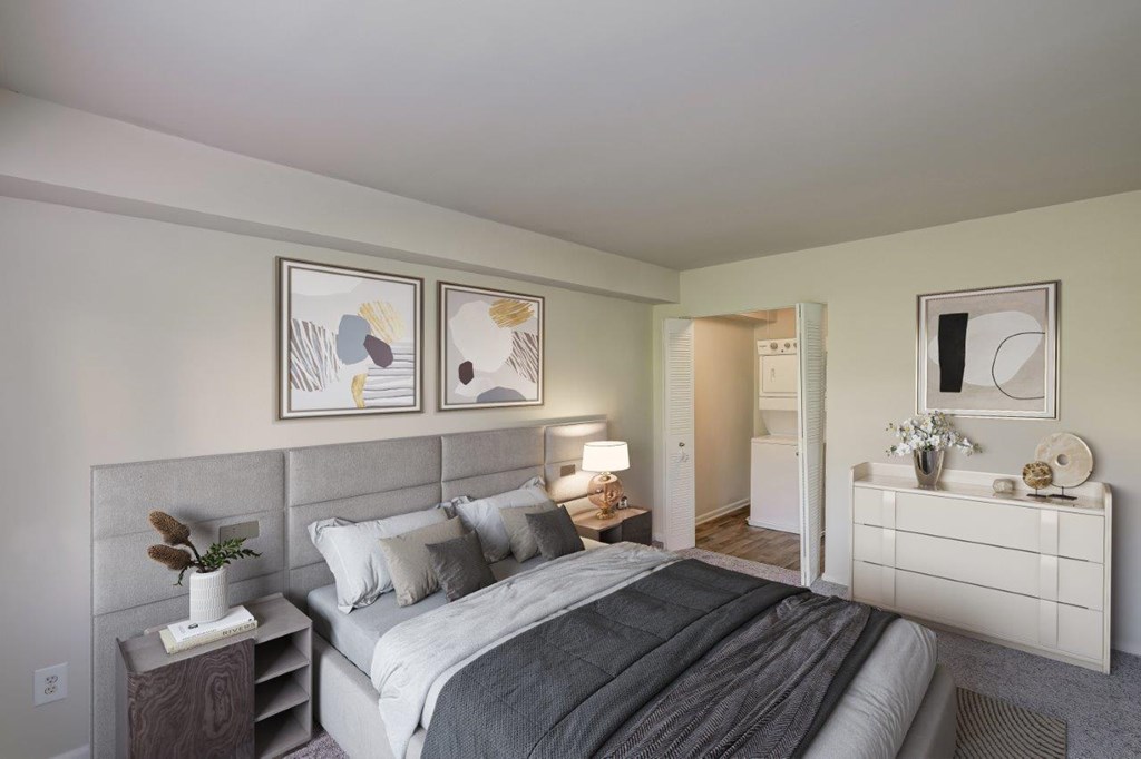 A bedroom with a large bed and a white dresser.