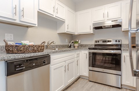 A kitchen with white cabinets and a black dishwasher.