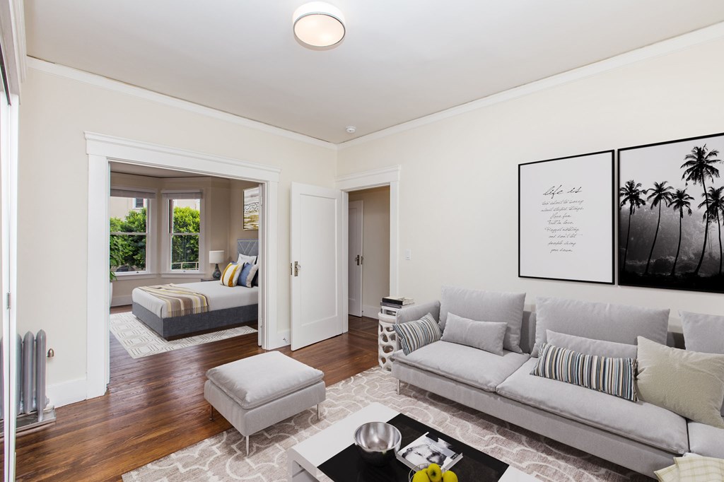 a living room with a couch and a coffee table and a bedroom with two beds