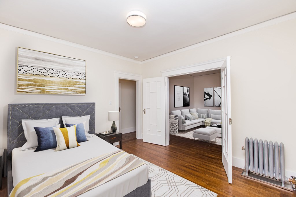 a bedroom with a bed and a door to a living room