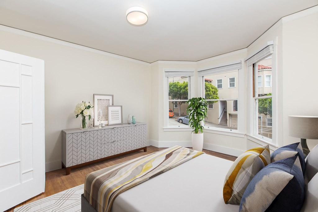 a bedroom with a bed and two windows