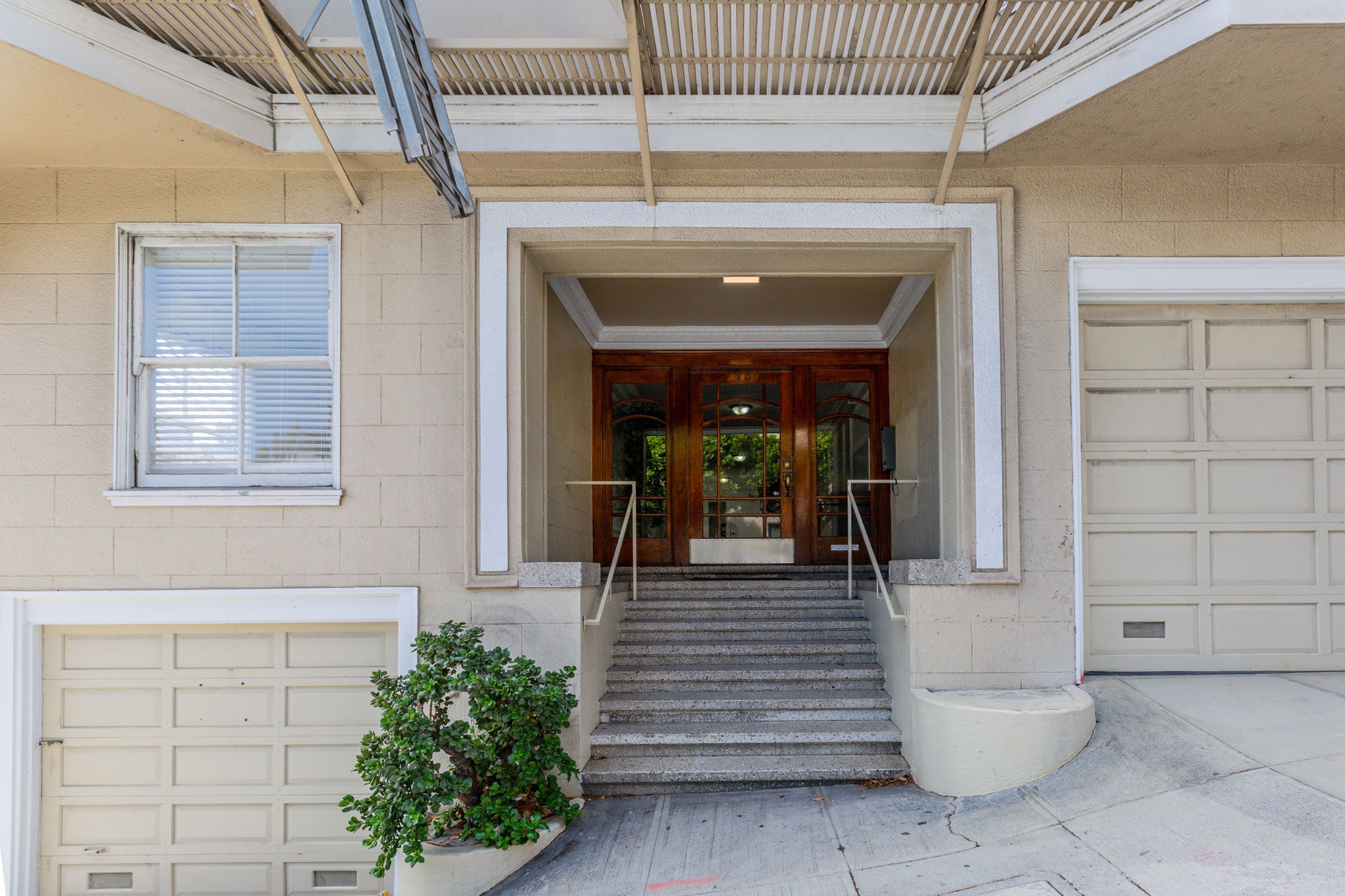 A white garage door is on the left of a house entrance.