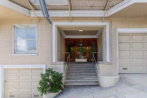 A white garage door is on the left of a house entrance.